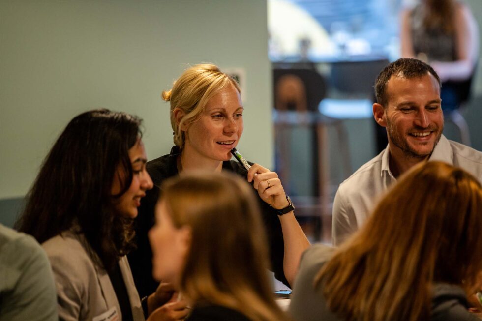 A woman and a man laugh in a group